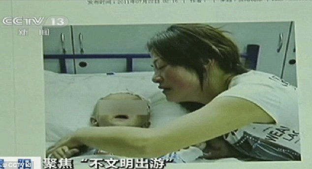 Horrifying ordeal: Chinese television shows the infant recovering in hospital with his mother after he had his testicle ripped off by a monkey